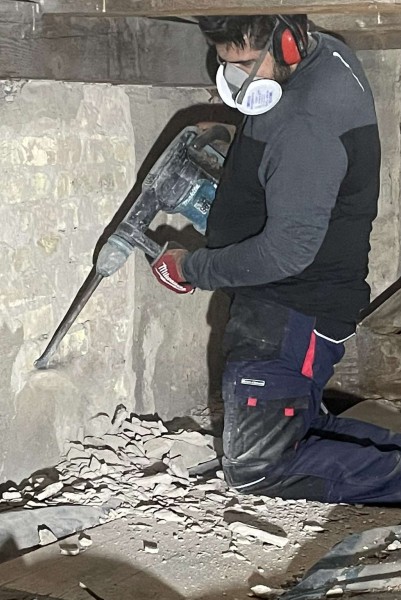 Entfernen von Putz, der mit dem Hausschwamm infiziert ist